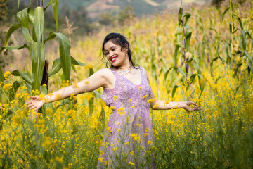 Foto de hermosa mujer feliz sonriendo y caminando en el bosque de flores amarillo ,con una corona...