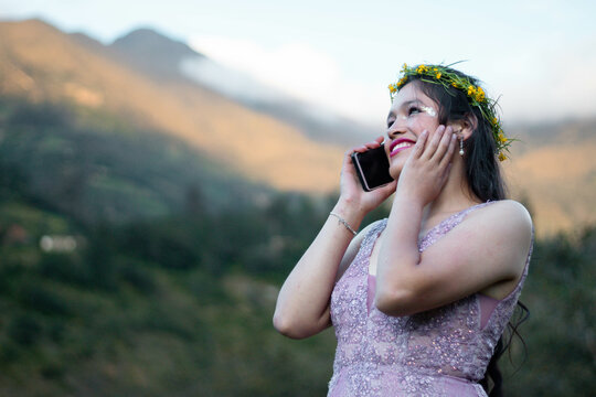 Foto de una mujer agradable hablando por celular mientras camina en un campo ,flores corona,