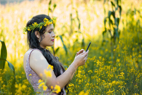 
Foto de una mujer sosteniendo un tel&eacute;fono celular en la mano en el campo, una linda chica mirando la pantalla del m&oacute;vil,