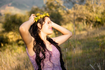 una mujer hermosa con un vestido ligero en un campo  con las manos levantadas sobre su cabeza en...