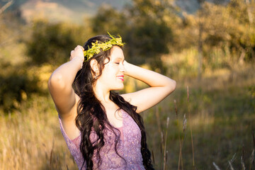 una mujer hermosa con un vestido ligero en un campo  con las manos levantadas sobre su cabeza en...