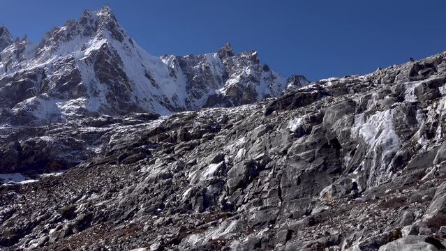 Rocky arid Himalaya terrain with little snow and blue sky with peaks
Long shot from Nepal, 2023 
