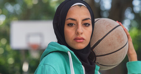 Close Up of Beautiful Muslim Young Woman Holding a Basket Ball While Looking at the Camera. Female...