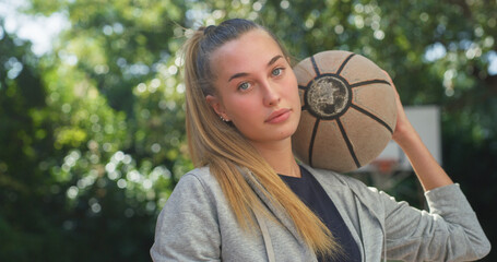 Portrait of Beautiful Blond Young Woman Holding a Basket Ball While Looking at the Camera in an...