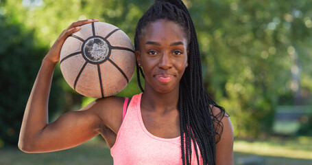 Portrait of Strong Black Young Woman Holding a Basket Ball While Looking at the Camera in an...