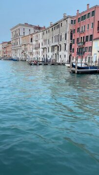 4K vertical video of a Venetian Grand Canal  with green waves near Rialto Bridge, Adriatic Mediterranean sea, Venice, Veneto region, Italy.