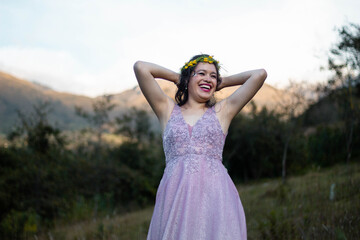 Foto de hermosa mujer feliz sonriendo de pi en el campo con una corona en la cabeza de...