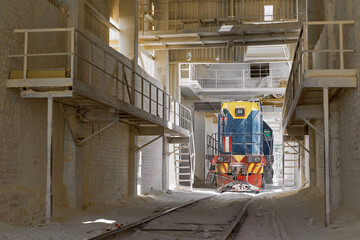 Shunting locomotive drives under service ramp at plant