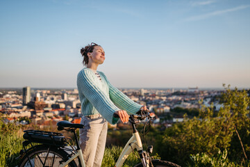 Young woman on electro bicycle, concept of commuting and ecologic traveling.