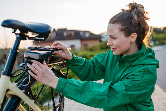Young woman with electro bicycle, concept of commuting and ecologic traveling.