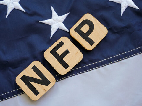 Cubes with the letters NFP Nonfarm Payrolls lie on the flag of the USA.