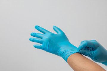 Male hand wearing blue latex gloves, medical, protective, white background