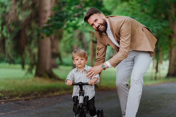 Single father with his little son spending together time in public park.