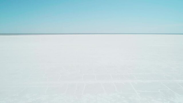 Aerial wide view of salt lake coast. Baskunchak in high tourist season at bright sunny day. Unique lake in the southwest of Russia, medicinal clay and mud deposite