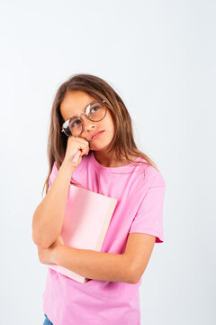 Pensive teenager girl holding notebook and thinking