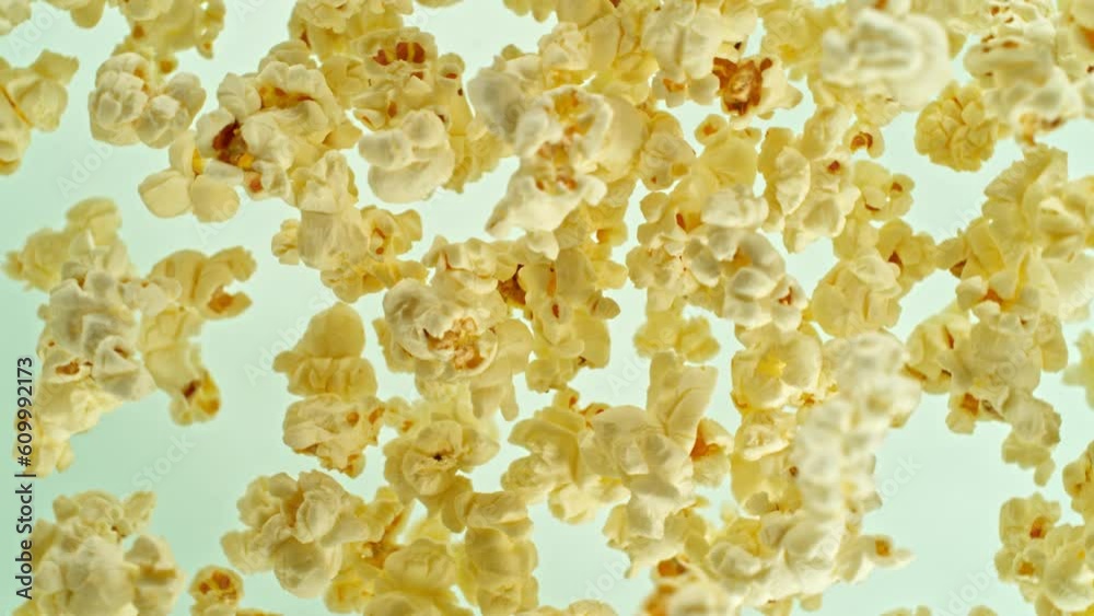 Poster super slow motion of rotating popcorn in the air. isolated on colored background. filmed on high spe