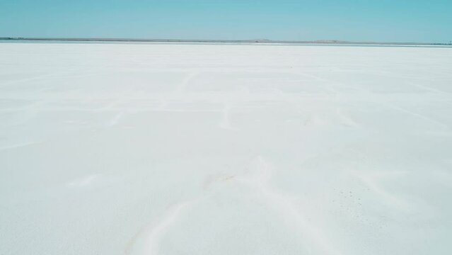 Aerial wide view of salt lake coast. Baskunchak in high tourist season at bright sunny day. Unique lake in the southwest of Russia, medicinal clay and mud deposite