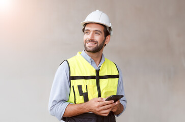 Male engineer in green reflective vest and hard hat using phone construction worker communication