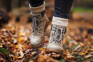 Leather hiking boot with knitted socks. Walking in autumn forest