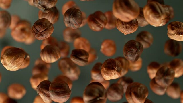 Super slow motion of rotating hazelnuts on black background. Filmed on high speed cinema camera, 1000 fps. Speed ramp effect.
