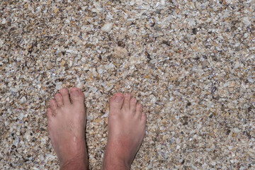 Pies parados en la arena de la playa