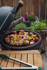 grilling shrimps skewers with salmon and vegetables on for grilling on a charcoal grill on the balcony at a summer day