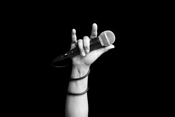 microphone in hand of singer raised his hand all the way up in live concert. hand sign mean love, love to sing concept - 610002141