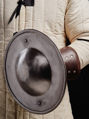 Man holding knight medieval buckler shield.