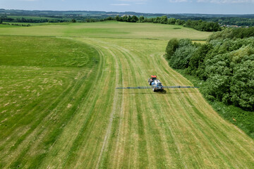 With the help of its spraying equipment, the tractor administers soil conditioners across the sown field to improve fertility.