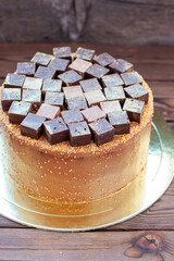 Chocolate brownie cake decorated with candy bars and truffles on rustic background. Cake for chocolate lovers