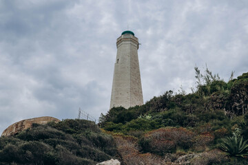Fototapeta na wymiar View of the lighthouse on the peninsula of Saint Jean Cap Ferrat in cloudy weather, on the French Riviera
