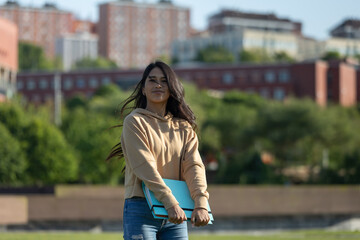 Fototapeta premium young girl with a blue folder, walking and studying on the campus of the university, hight school or institute.