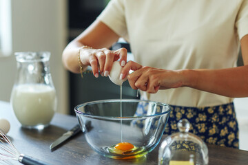 Close up hand add egg to the dough for pancake. Ingredients for focaccia, pie, pizza, ravioli, pasta. bakery, cookbook, cooking blog.