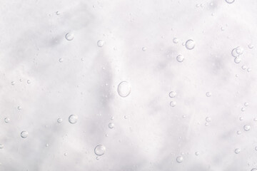 Cosmetic gel, serum transparent sample. Liquid cream with bubble texture. Gel texture of a cosmetic product. Clear liquid lotion for skin care.