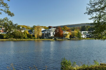 Fototapeta na wymiar Le lac des Doyards sous un ciel clair en fin de journée d'automne à Vielsalm