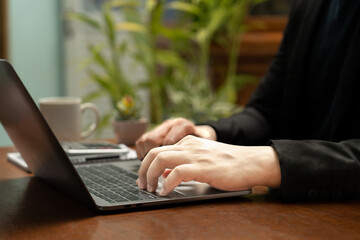 Businessman sitting at table with laptop calculator The notebook lay on his desk. Ready to move forward with business and communicate online via his mobile phone and notebook.close up.calculator.