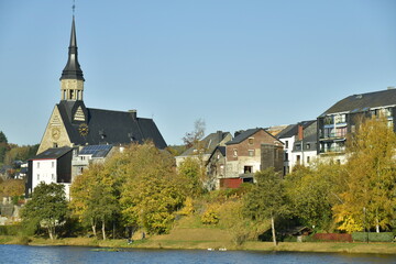 Fototapeta na wymiar Le lac des Doyards et le village de Wielsalm avec son église paroissiale de Saint Gengoux dans un environnement bucolique à l’extrême nord de la province de Luxembourg 