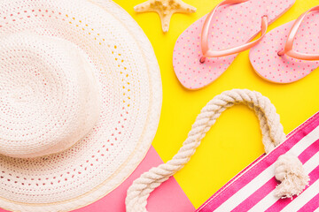 Beach accessories straw hat and seashell on colored table. Summer concept background
