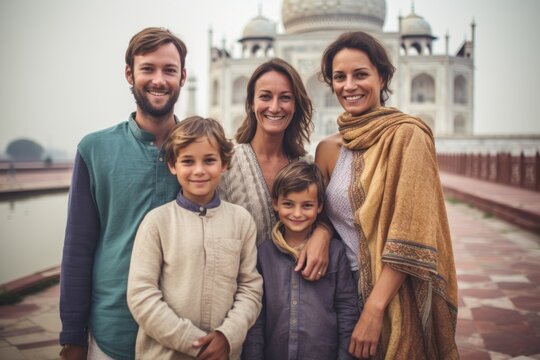 Portrait of happy family standing in front of Taj Mahal in Agra, India
