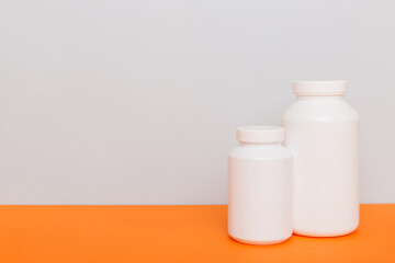 supplement pills with medicine bottle health care and medical top view. Vitamin tablets. Top view mockup bottle for pills and vitamins with green leaves, natural organic bio supplement, copy space