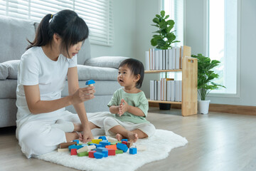 Happy Asia mother play and learn toy blocks with the little girl. Funny family is happy and excited in the house. Mother and daughter having fun spending time together. Holiday, Activity, development