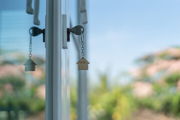 Landlord key for unlocking house is plugged into the door. Second hand house for rent and sale. keychain is blowing in the wind. mortgage for new home, buy, sell, renovate, investment, owner, estate..