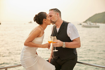 couple drinking and kissing in luxury yacht