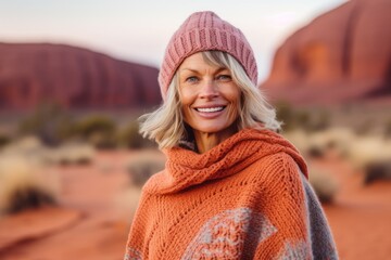 Lifestyle portrait photography of a grinning woman in her 50s that is wearing a cozy sweater near the Uluru (Ayers Rock) in Northern Territory Australia . Generative AI