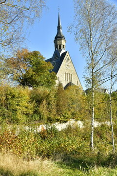 Le clocher de l'&eacute;glise paroissiale de Saint Gengoux &eacute;mergeant de la v&eacute;g&eacute;tation luxuriante en automne &agrave; Vielsalm