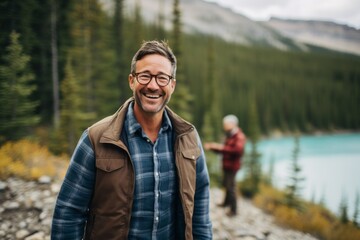 Lifestyle portrait photography of a satisfied man in his 40s that is smiling with friends at the Banff National Park in Alberta Canada . Generative AI