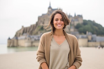 Fototapeta premium Beautiful young woman at Mont Saint Michel in Normandy, France.
