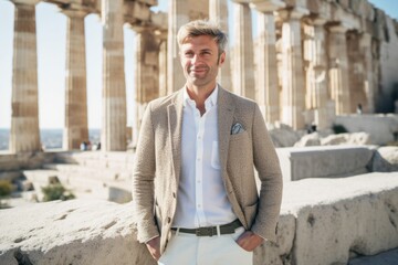 Portrait of a handsome young man standing in front of the temple of Hephaestus in Athens, Greece