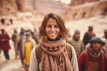 Fototapeta premium Lifestyle portrait photography of a pleased woman in her 40s that is smiling with friends at the Petra in Maan Governorate Jordan . Generative AI
