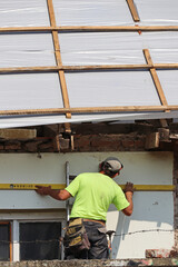 Construction worker works at the roof restoration